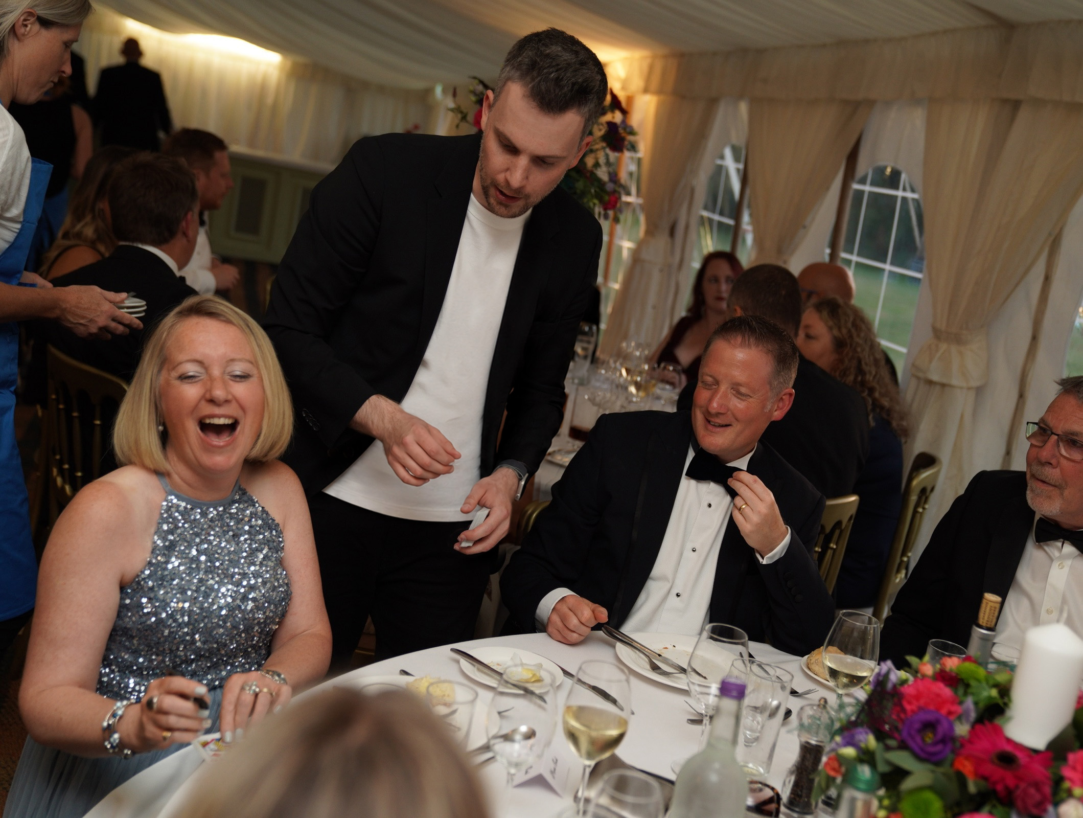 Marc performing close-up magic for guests at an elegant wedding